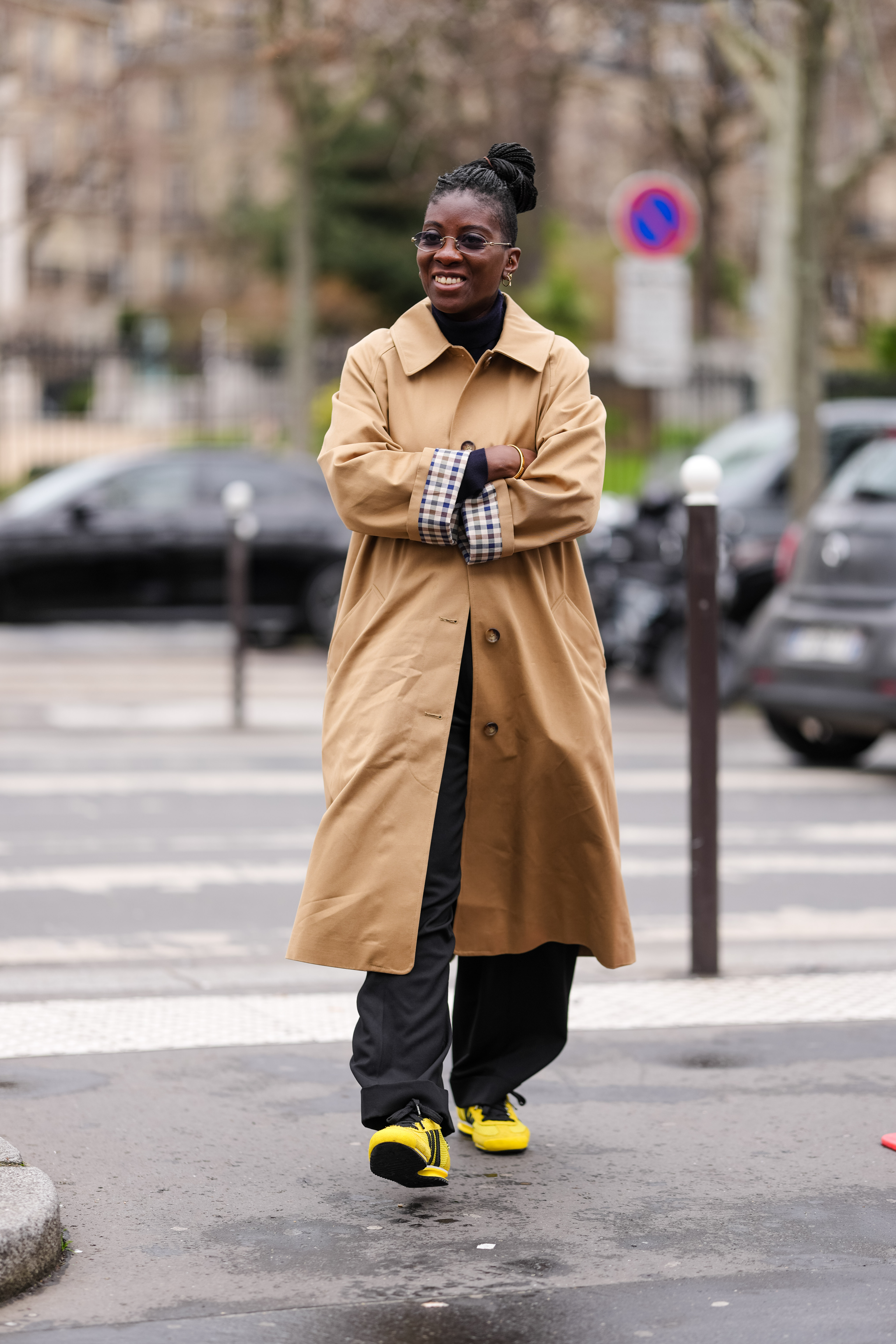 Nikki Ogunnaike wears the sezane trench coat with sneakers at parish fashion week