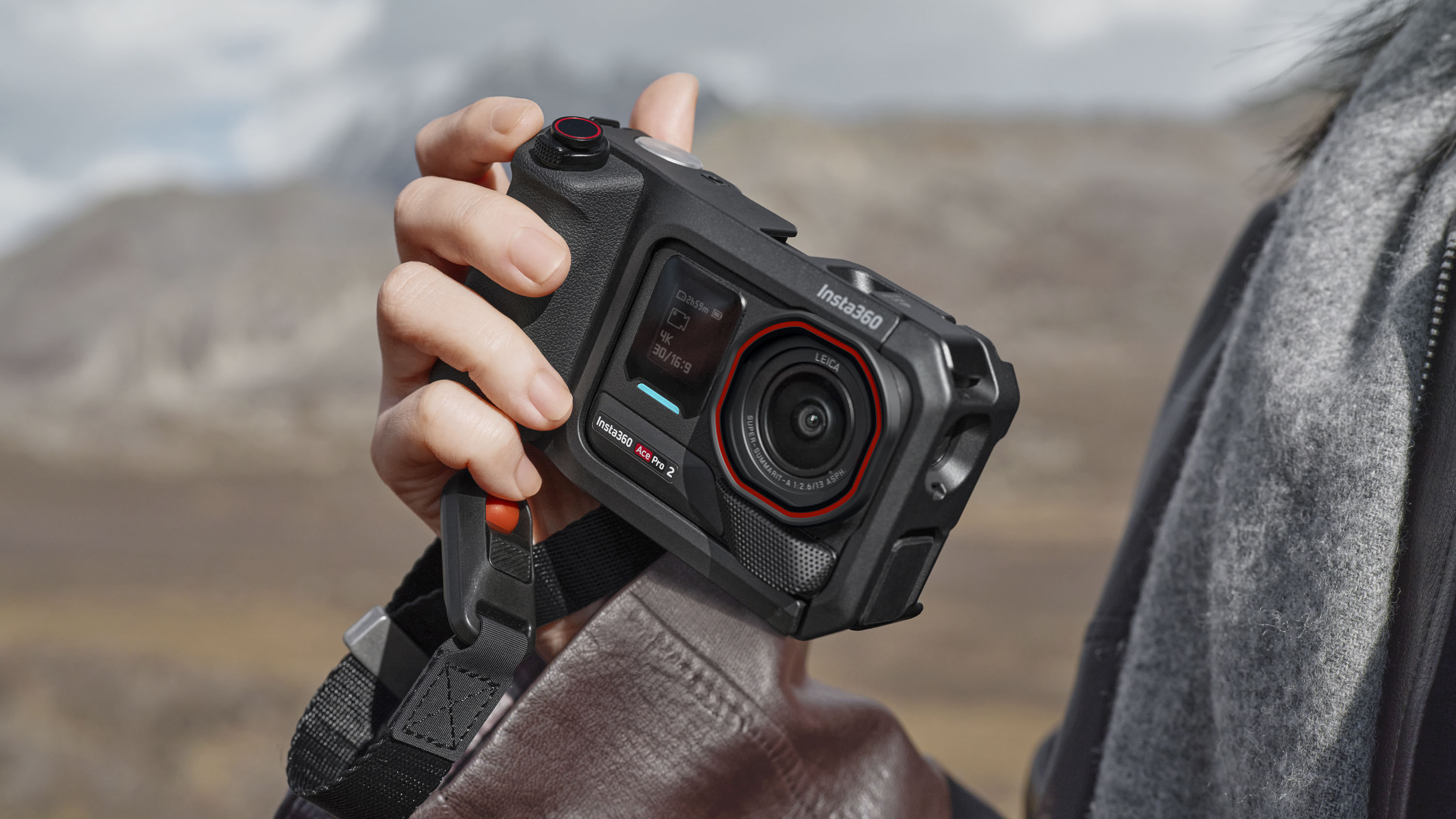 Insta360 Ace Pro 2 action camera housed inside grip accessory, in user's hand