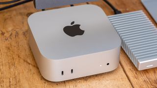 Mac mini M4 on a table next to a portable SSD