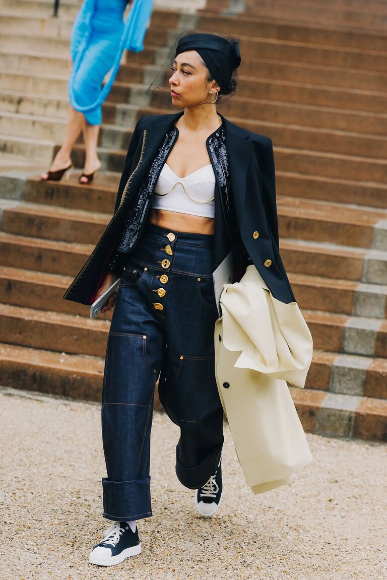 a woman at paris fashion week wearing a denim-on-denim outfit and black sneakers