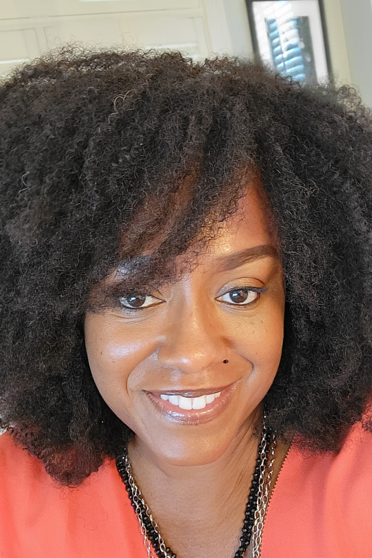 Darlese Robinson wearing Bobbi Brown&#039;s concealer stick in a coral top.