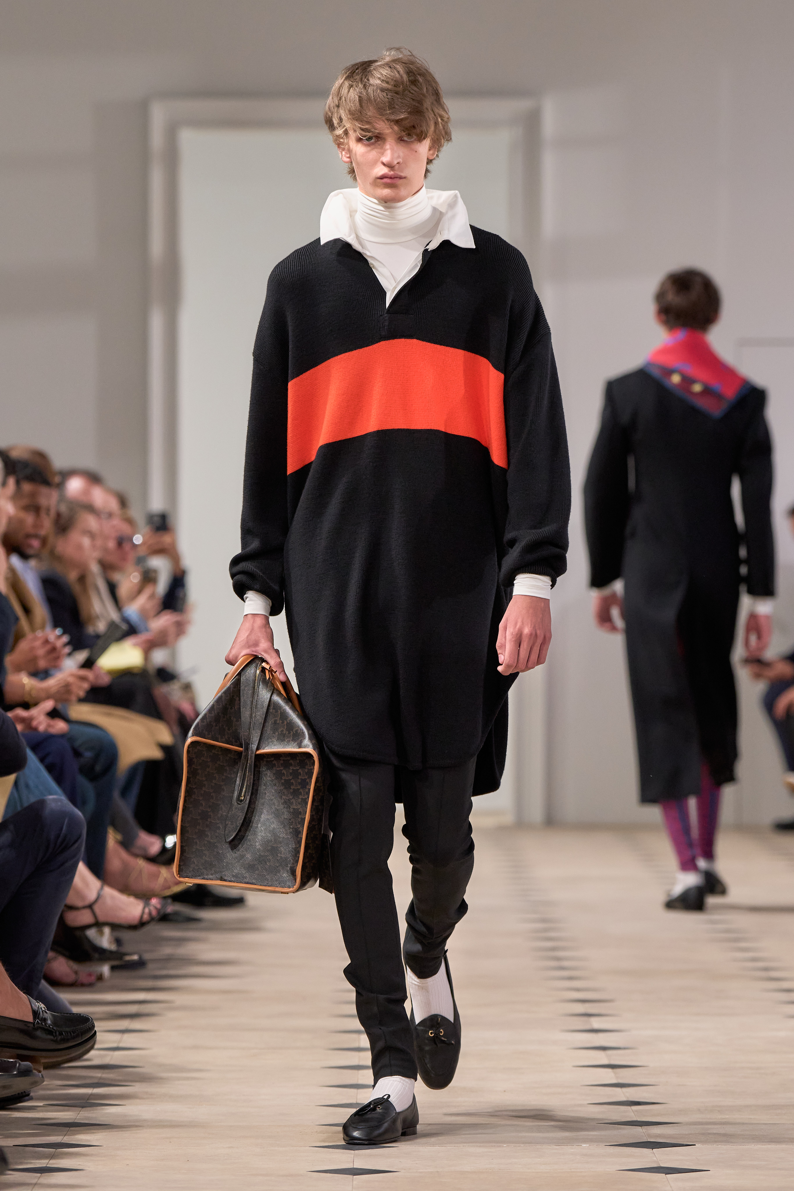 a model walking the Celine runway in a rugby shirt and celine bag