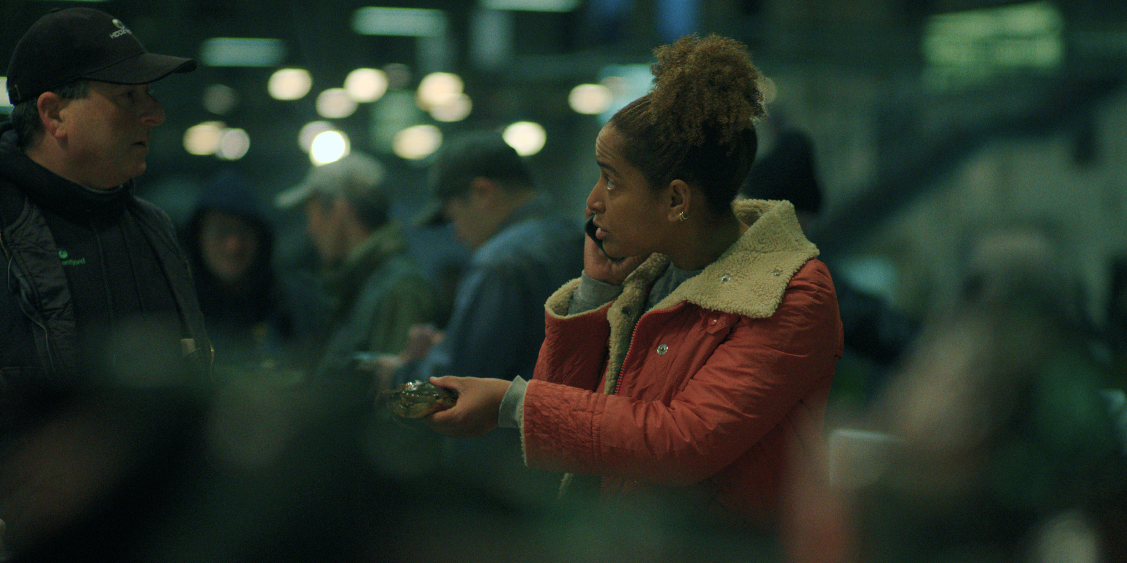 Amaka Okafor as roxie wearing a red jacket shopping at a food market in black rabbit