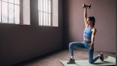 A woman performing dumbbell lunges