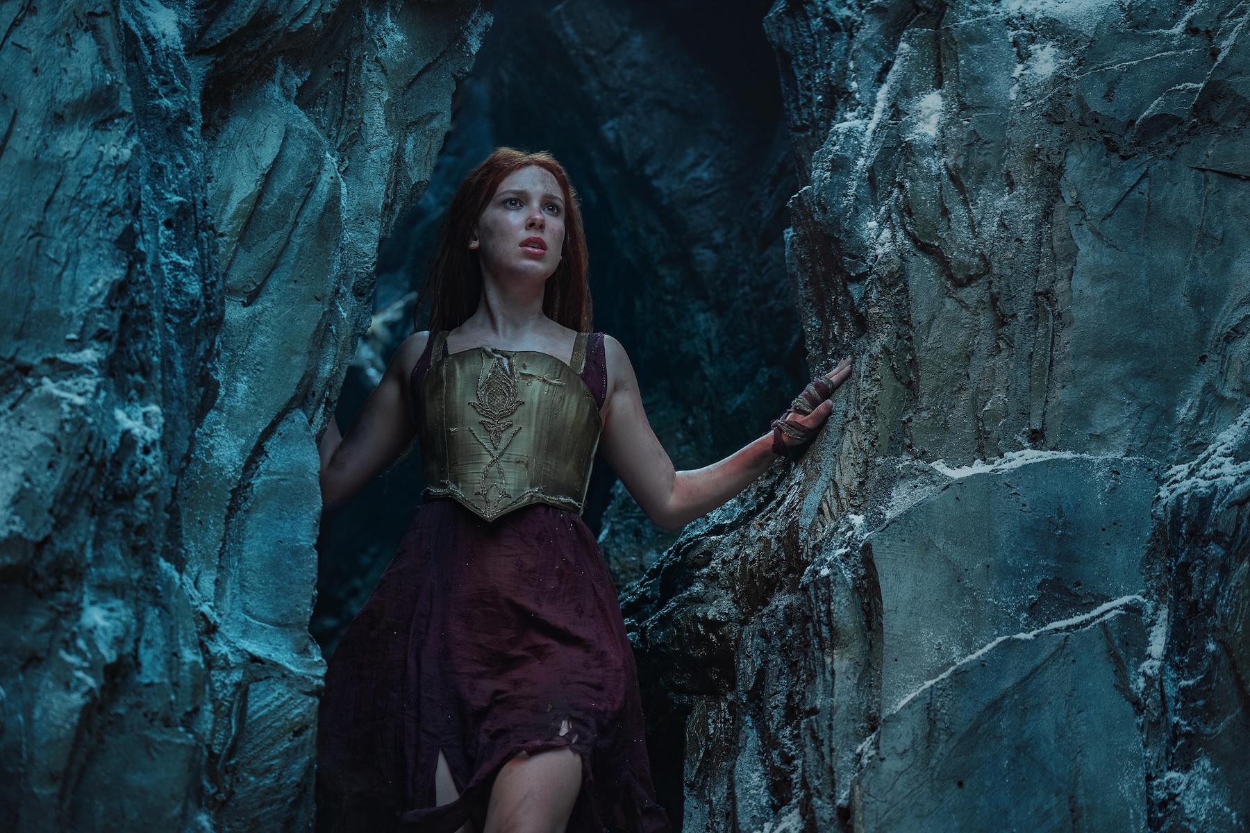 millie bobby brown stands in a cave in the netflix movie &#039;damsel&#039;