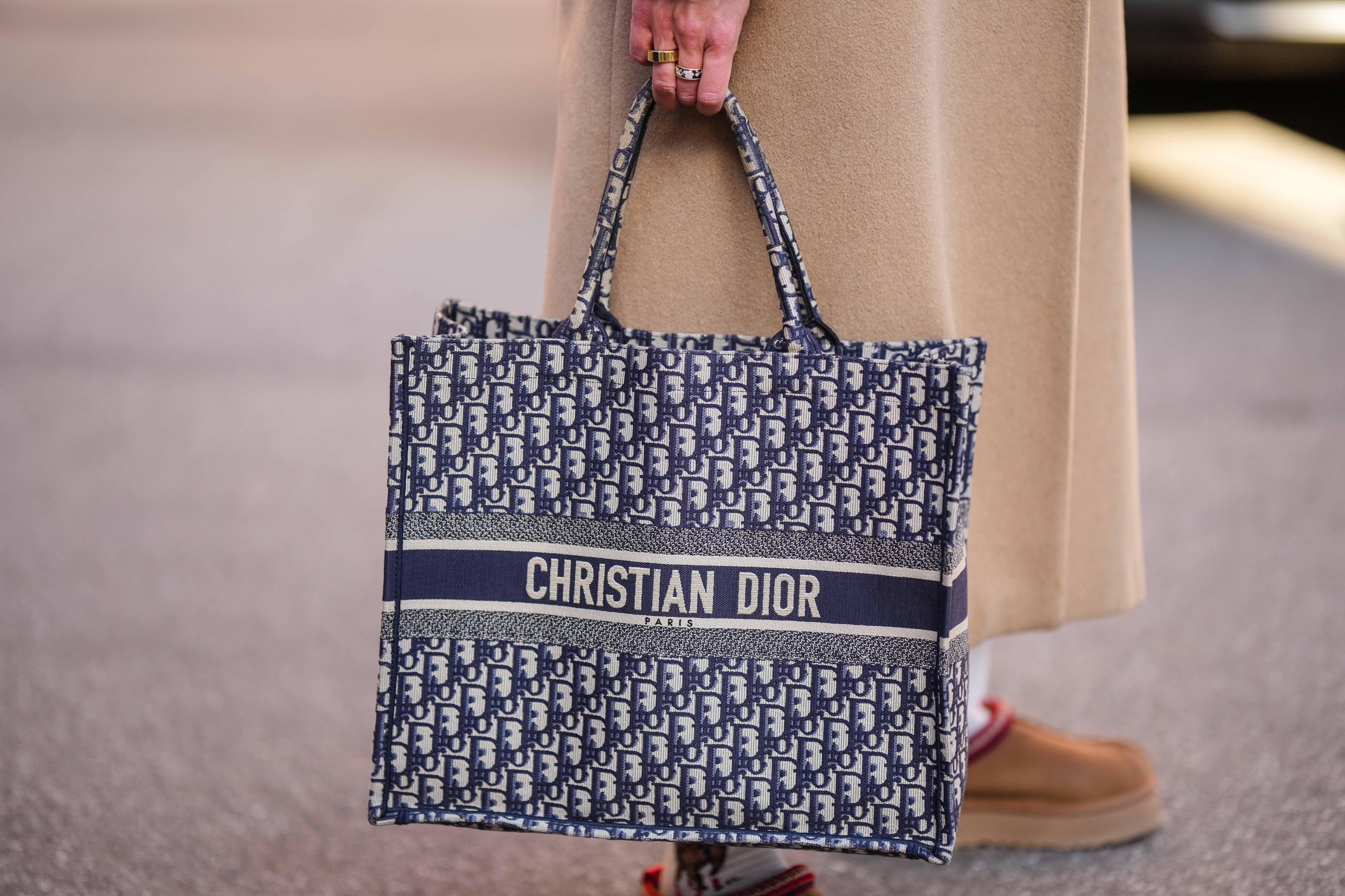 a woman in Paris holding a dior book tote