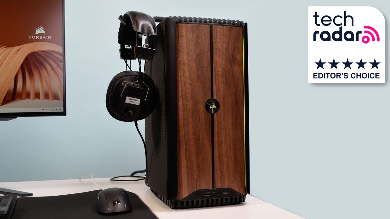 A Corsair One i500 on a desk with headphones attached