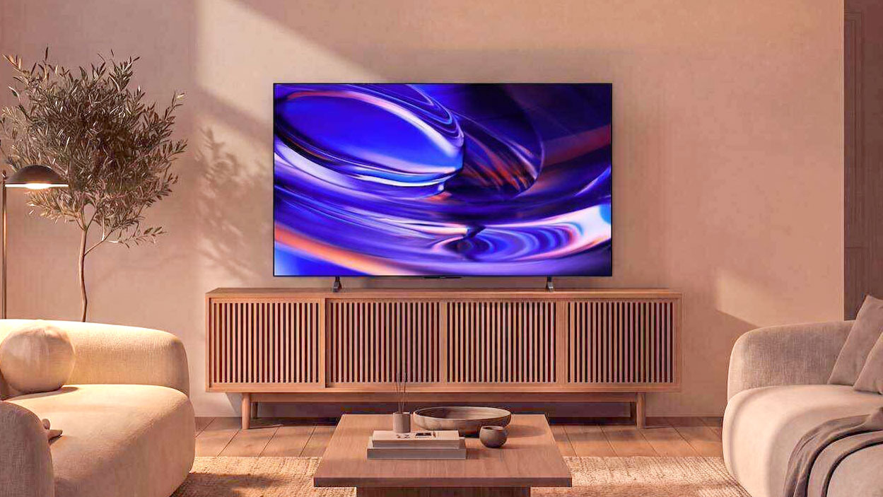 The Sony Bravia 6 OLED TV displaying colorful, abstract imagery from atop a credenza in a dimly lit living room
