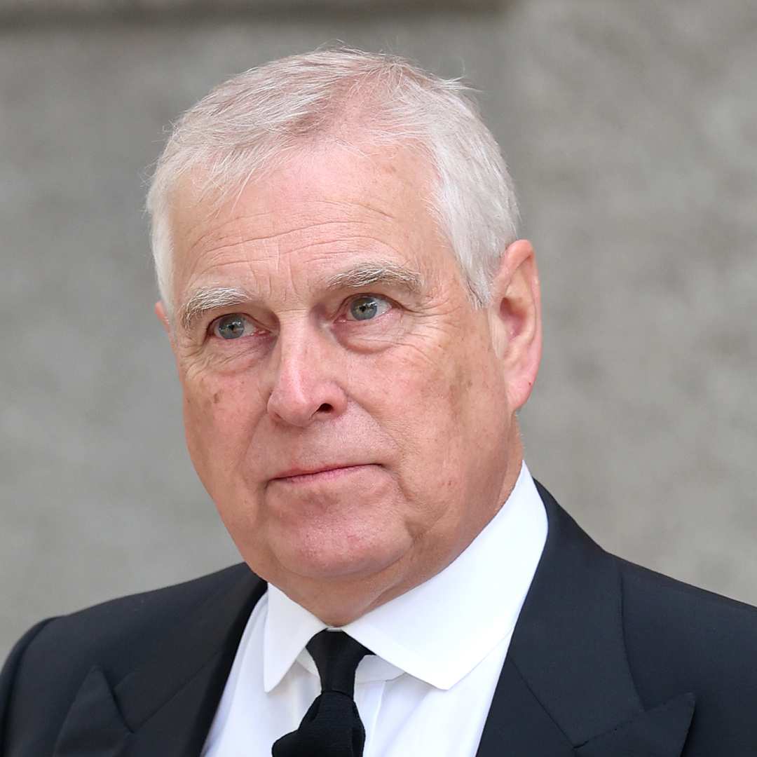 Prince Andrew grimacing in a dark suit