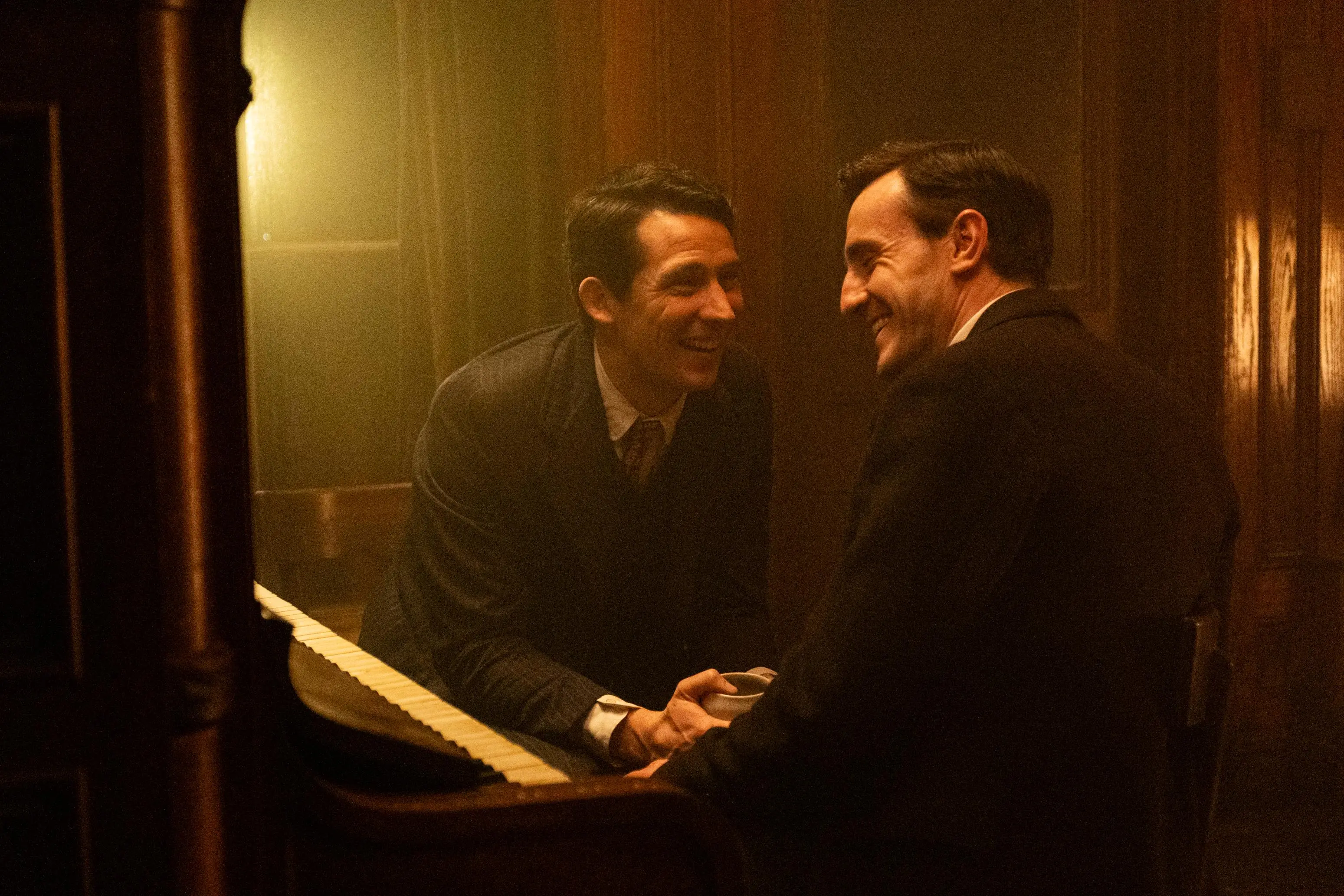 josh oconnor and paul mescal laugh with each other while both wearing suits in the period piece the history of sound