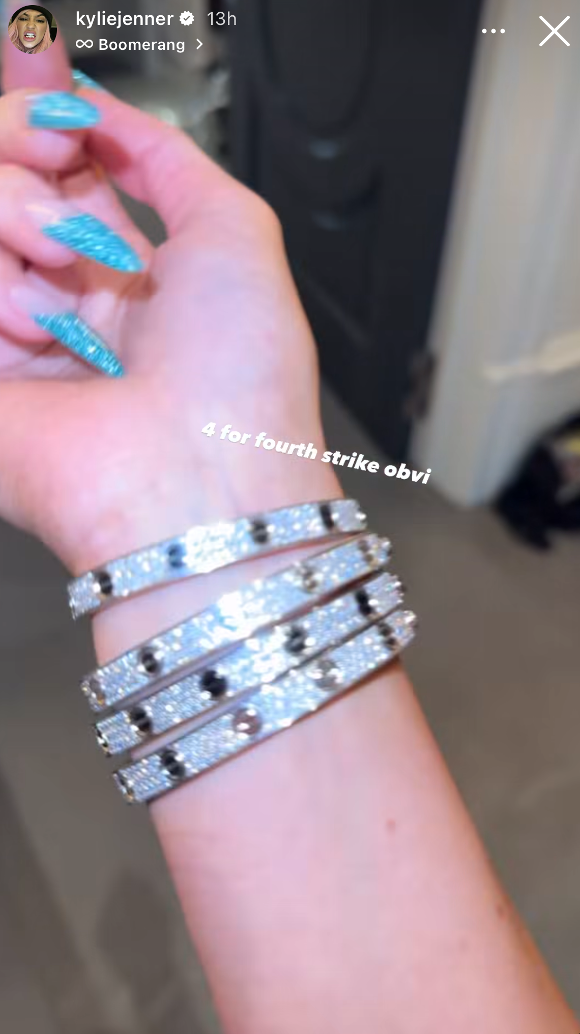 a person wearing a sparkly turquoise manicure and four diamond bracelets