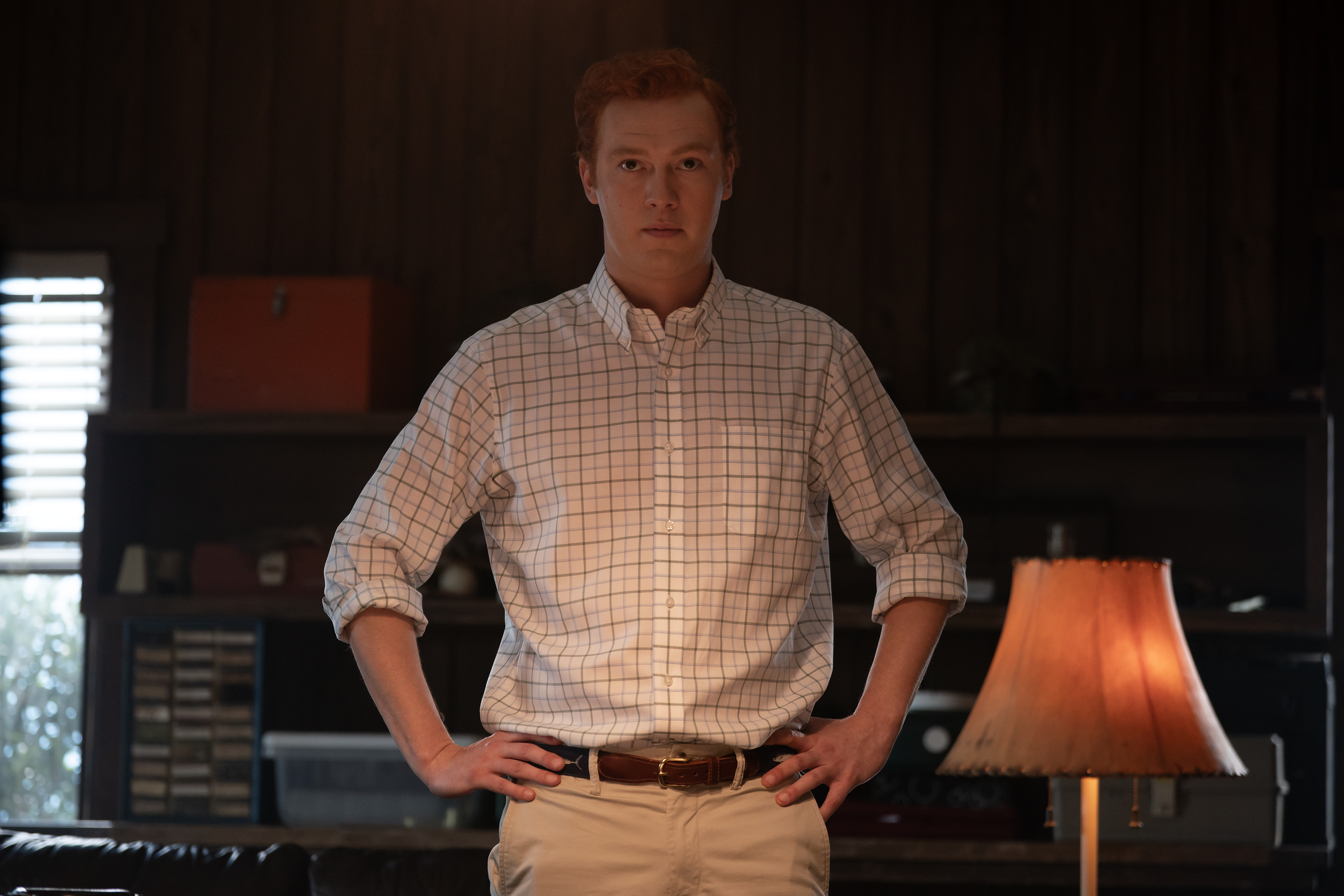 will harrison as Buster Murdaugh holding his hands on his hips in a dark room in a still from murdaugh a death in the family