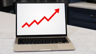A MacBook screen showing a red arrow rising