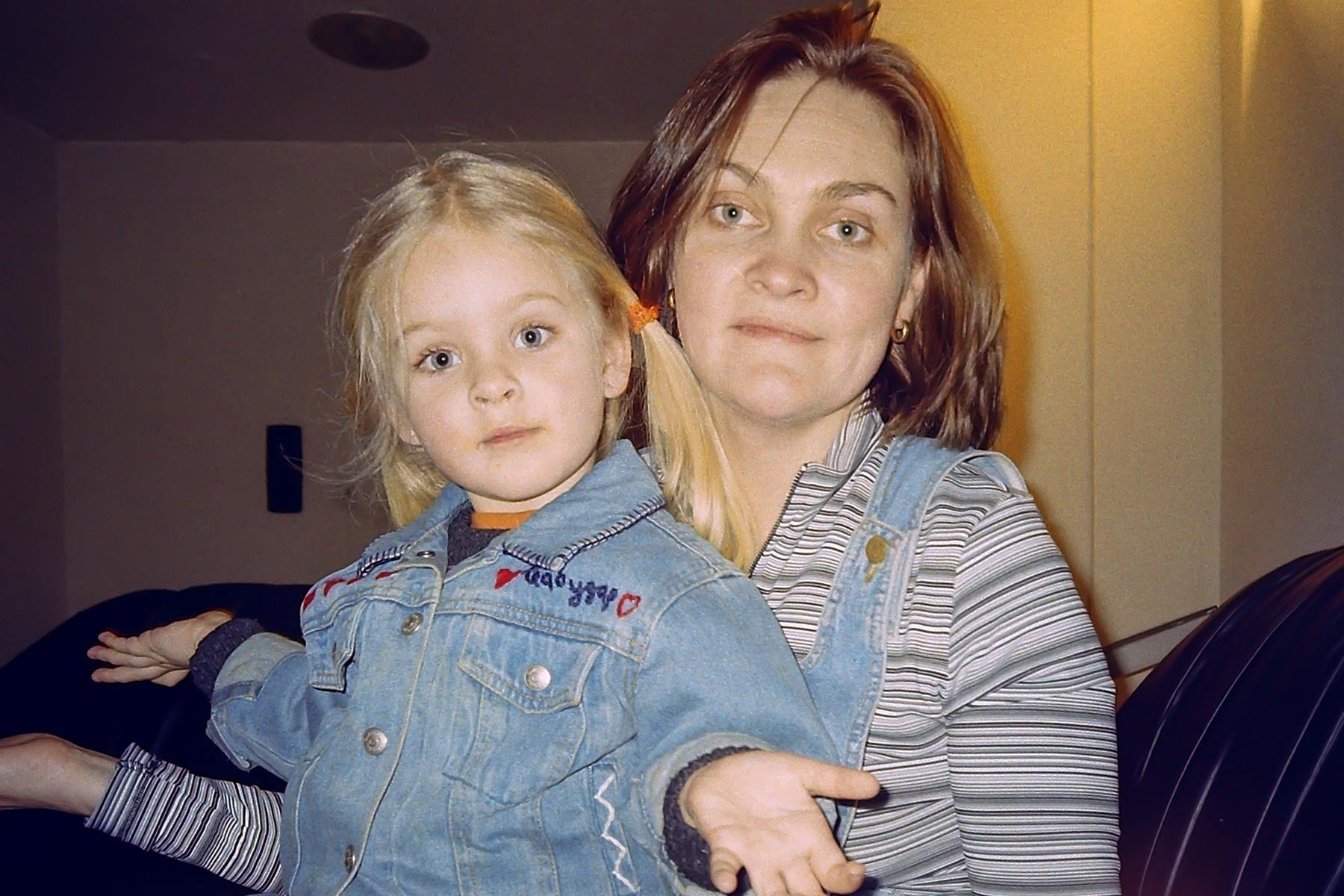 Lisa Vedernikova Khanna as a young girl sitting beside her mother, both looking toward the camera.