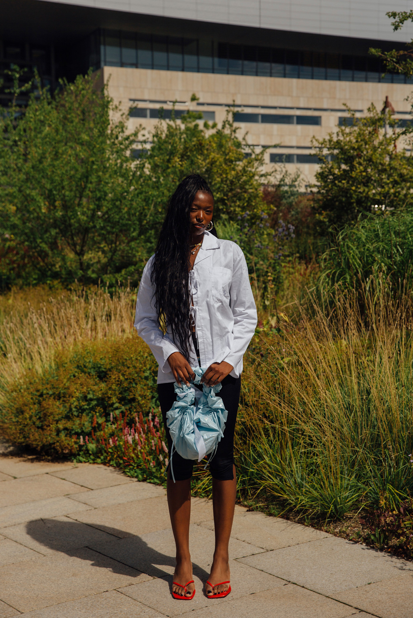 woman wearing button-down shirt and capri pants and red heels in copenhagen