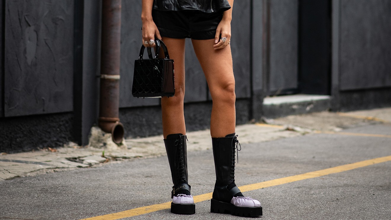 legs with no hair wearing boots on the street