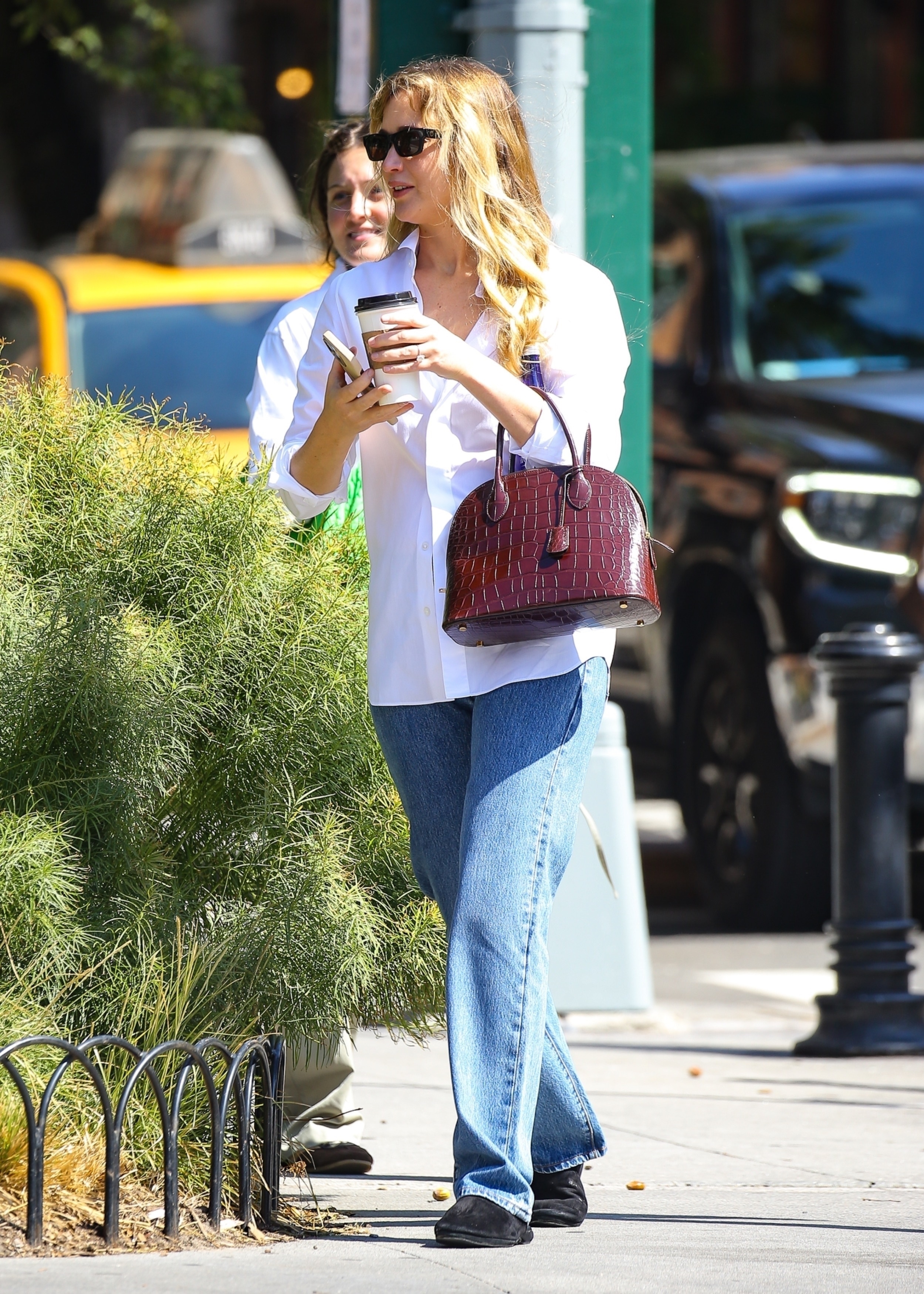 Jennifer Lawrence wearing black charvet slippers, jeans, a white shirt, and red bag in new york city