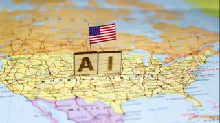 The word &ldquo;AI&rdquo; is composed of wooden blocks on a map of the United States with the US flag, reflecting the advancement of artificial intelligence in the American economic and technological landscape