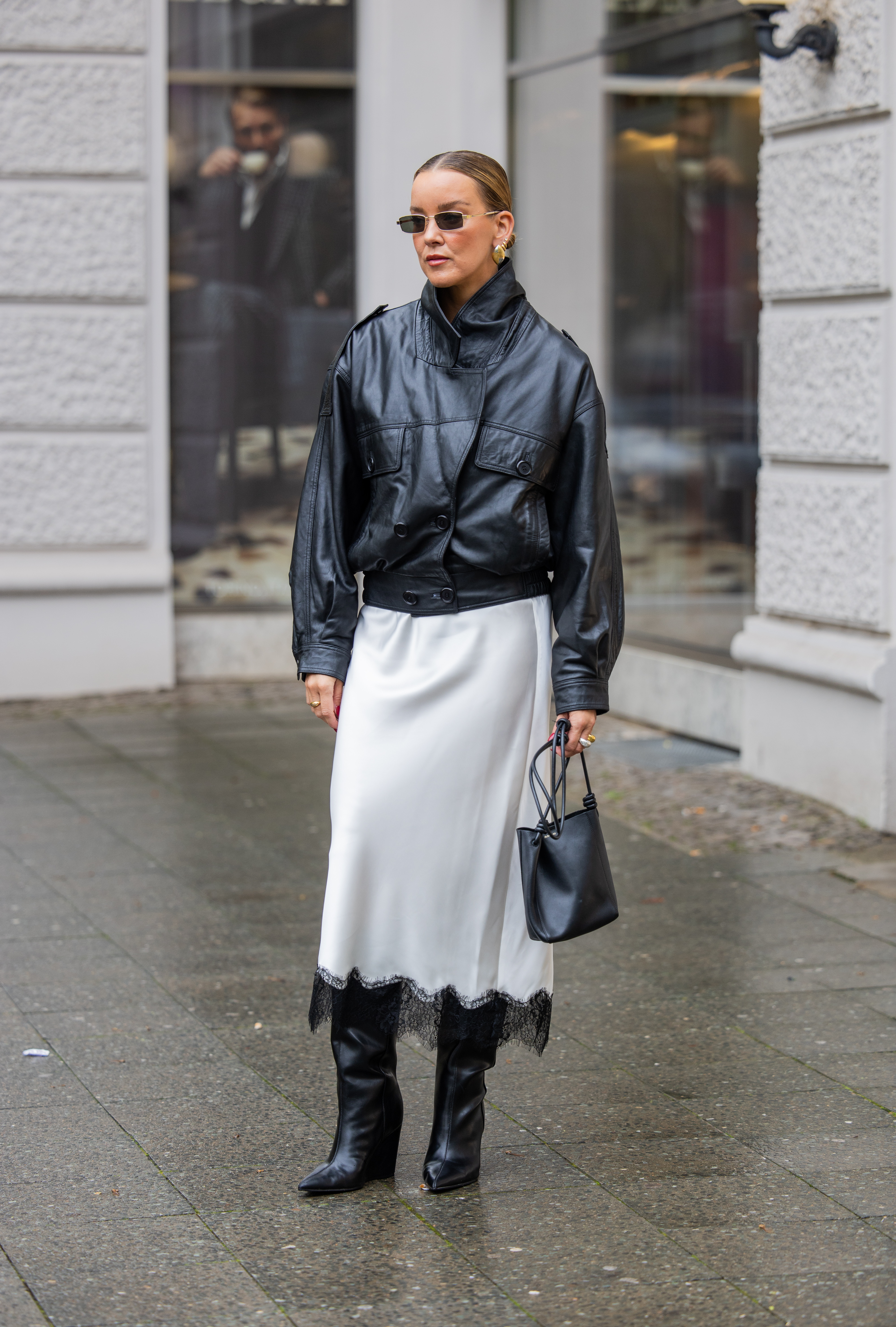 woman wearing a leather jacket, a lace-trimmed skirt, and boots