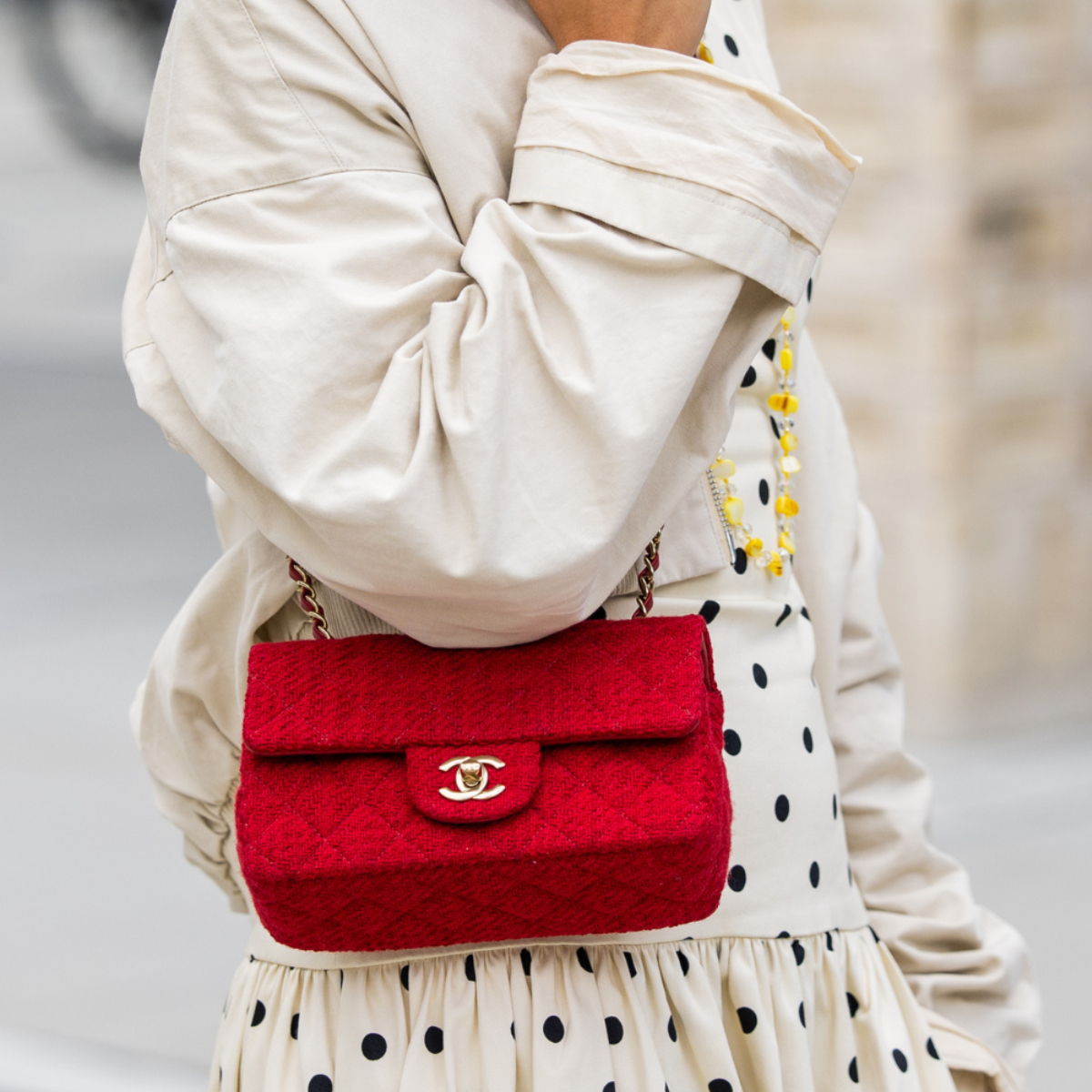 woman wears red chanel crossbody bag polka dot dress