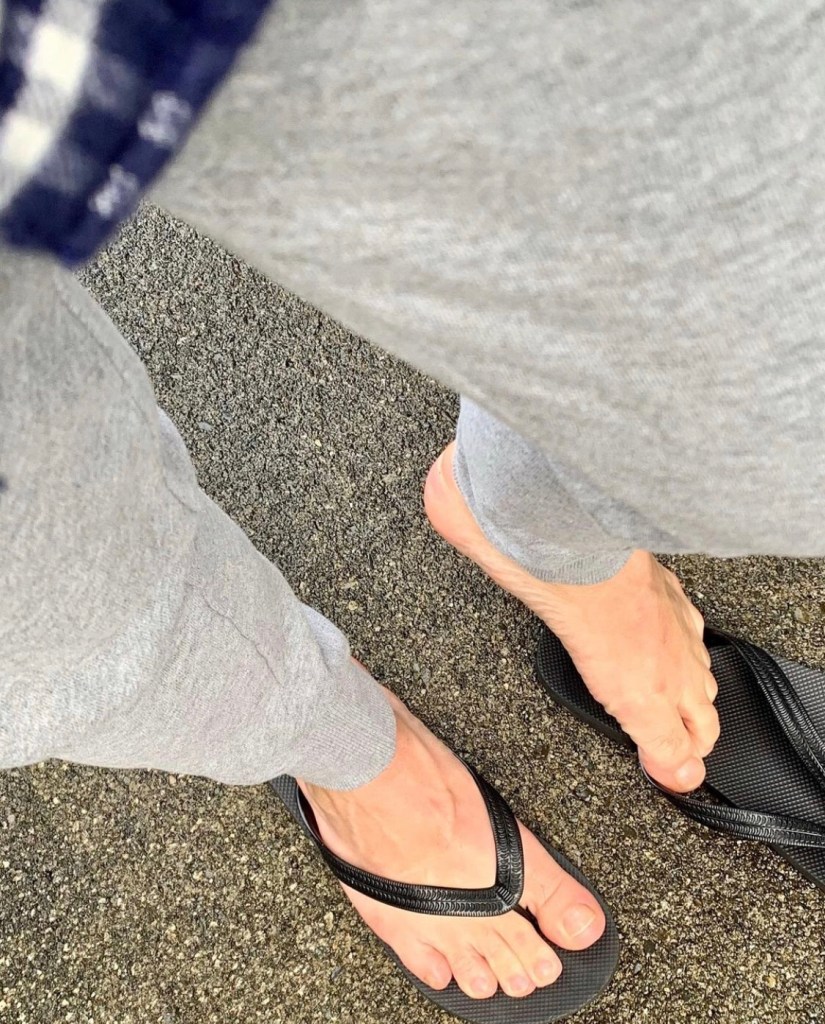 Bro.toes barefoot in flip flops and sweatpants