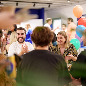 A group of Figmates cheering with balloons in an office