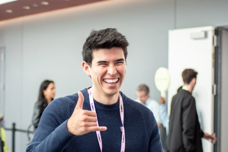 A Config conference attendee giving the hang ten hand symbol while smiling