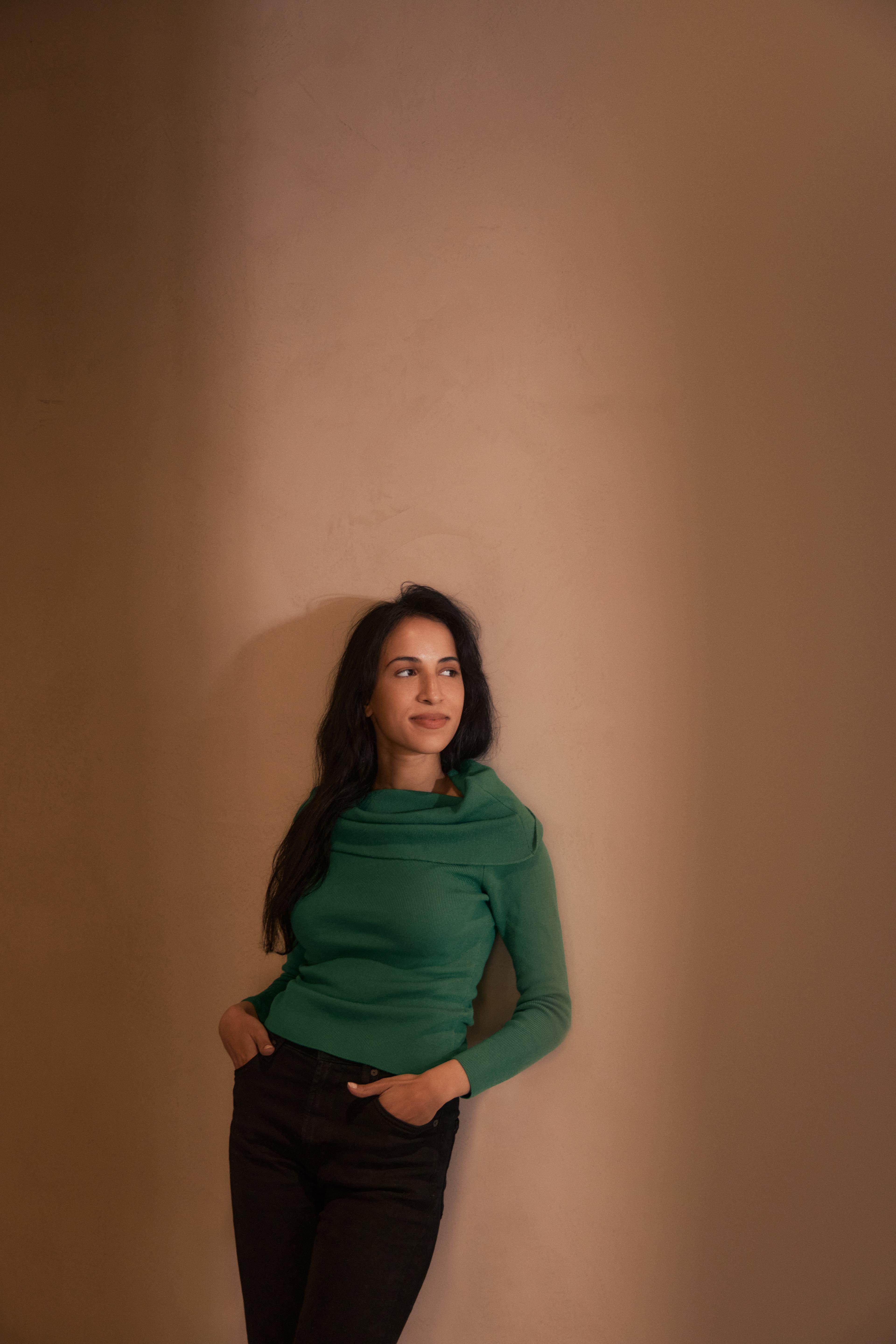 Photography by Derek Yarra of Noor Siddiqui standing against a wall | Meridian by Mercury