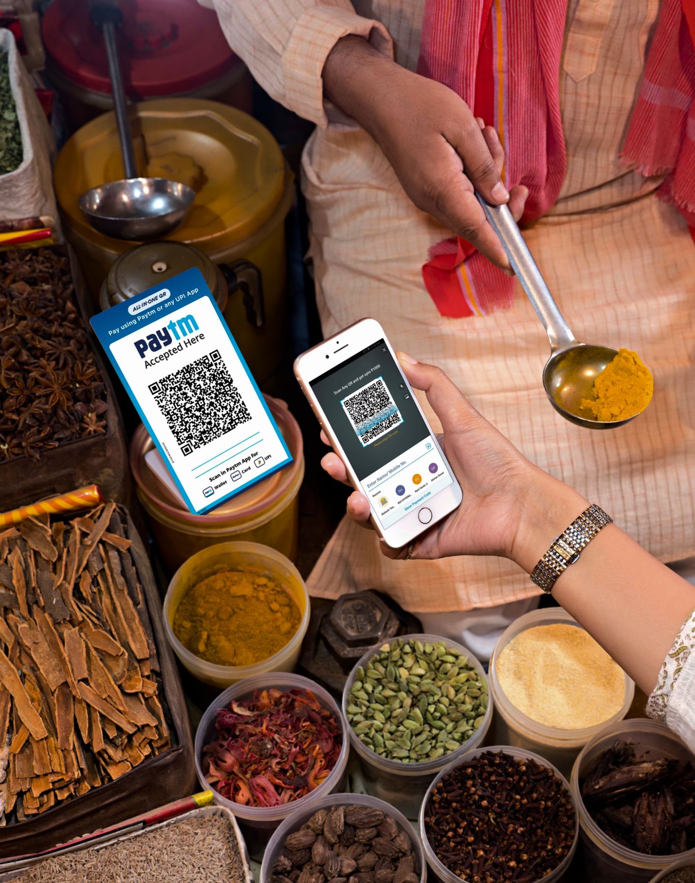 A customer using Paytm to pay for spices in a market