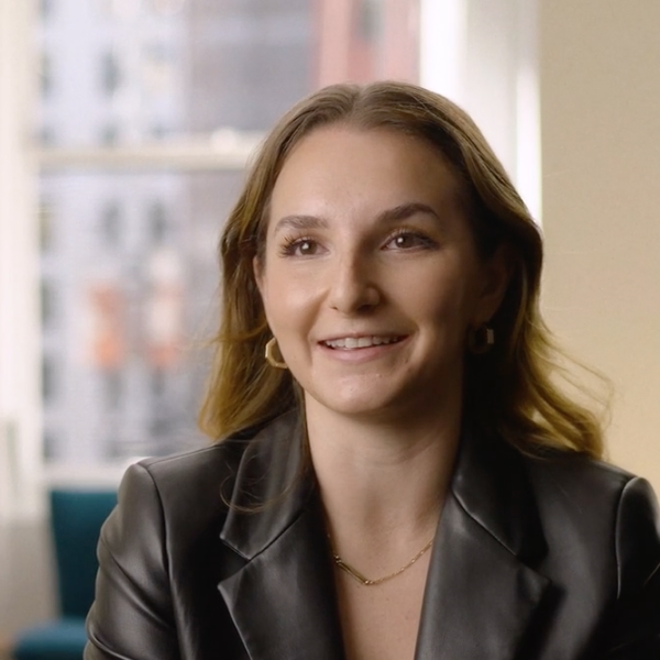 A woman in a black leather jacket is smiling.