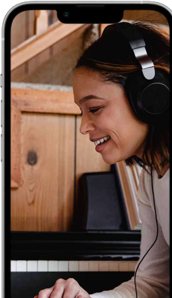 An image of a smartphone showing a wooden background with a portrait of a woman wearing headphones.