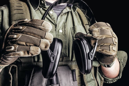 Strelecké slúchadlá v rukách vojaka