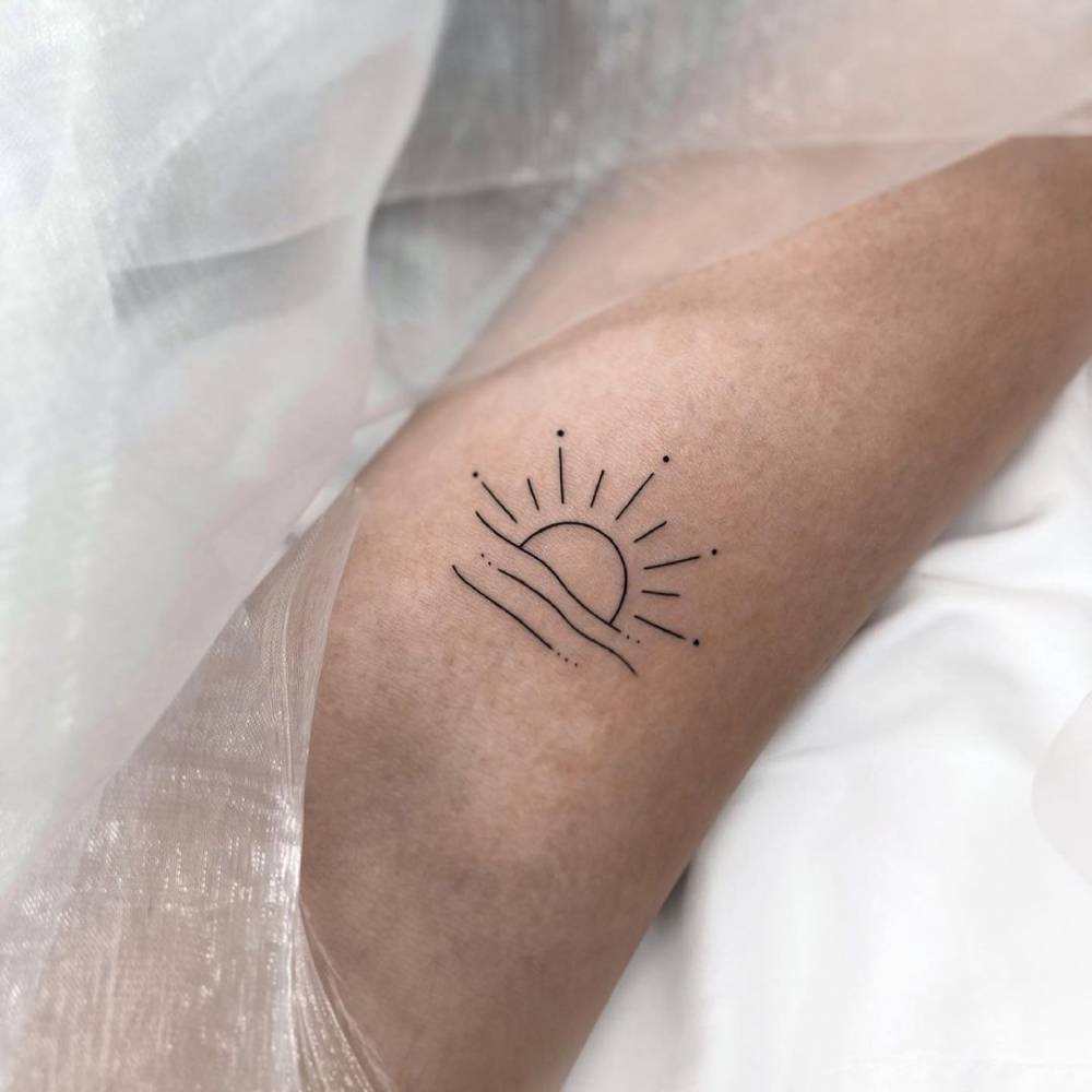 Minimalist sunset tattoo on the bicep.