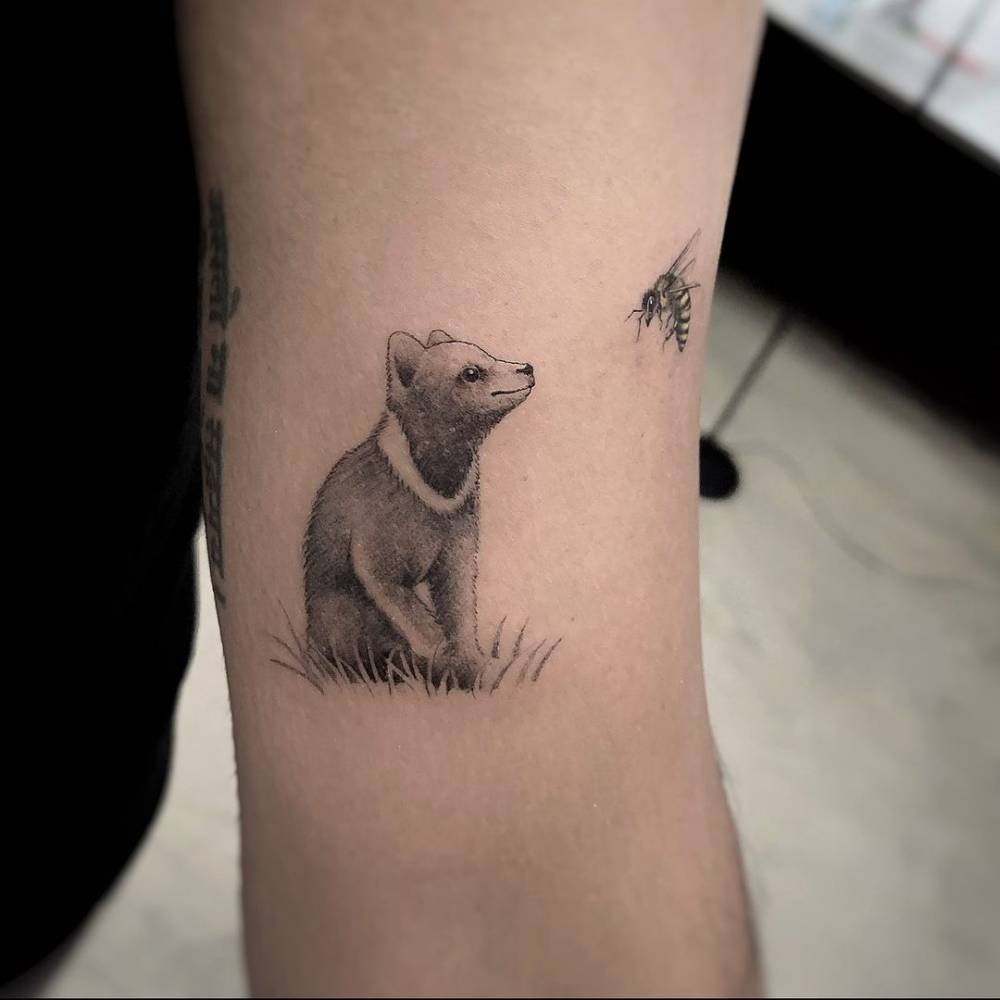 Micro-realistic bear cub tattoo on the bicep.