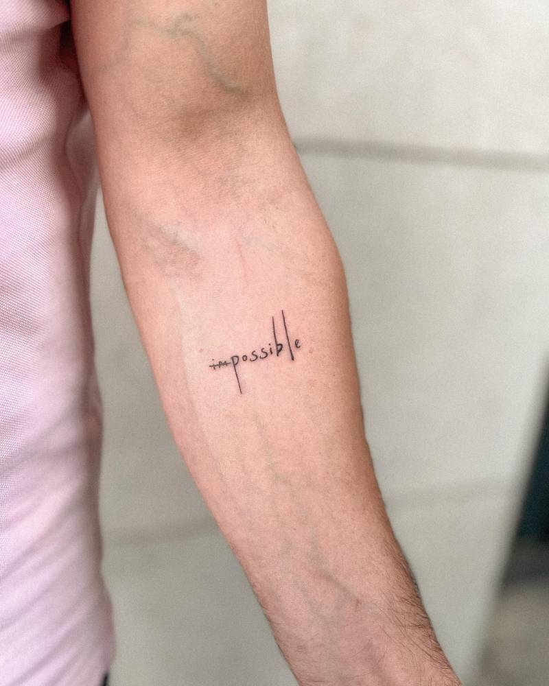 Tattoo of the word "impossible" located on the inner forearm.