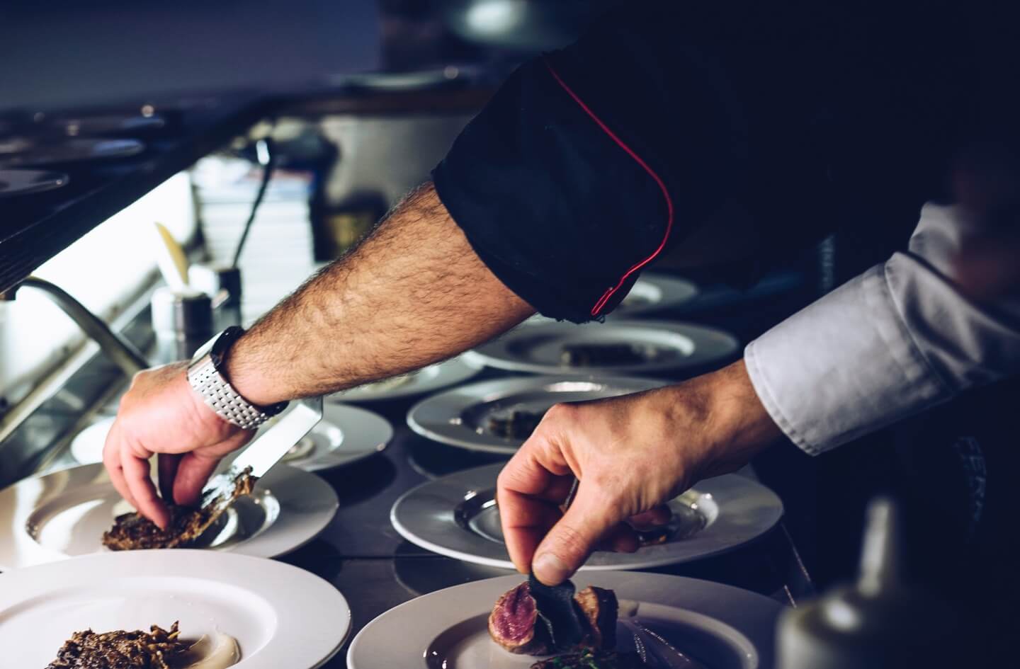 hands placing food on white plate