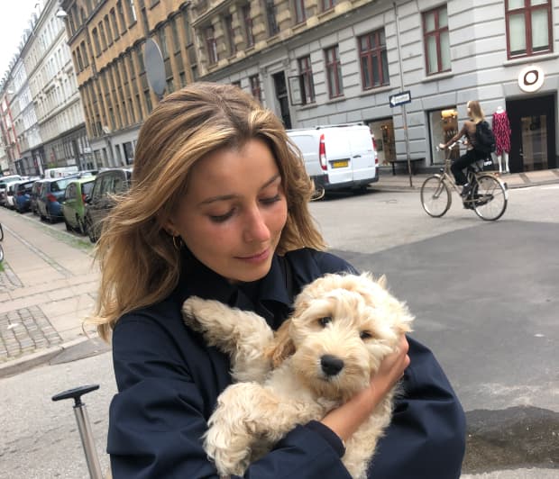 Foto de una mujer con un perro en brazos.