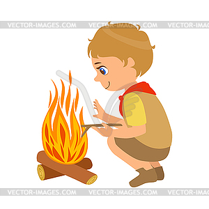 Boy scout squatting near bonfire, colorful character.