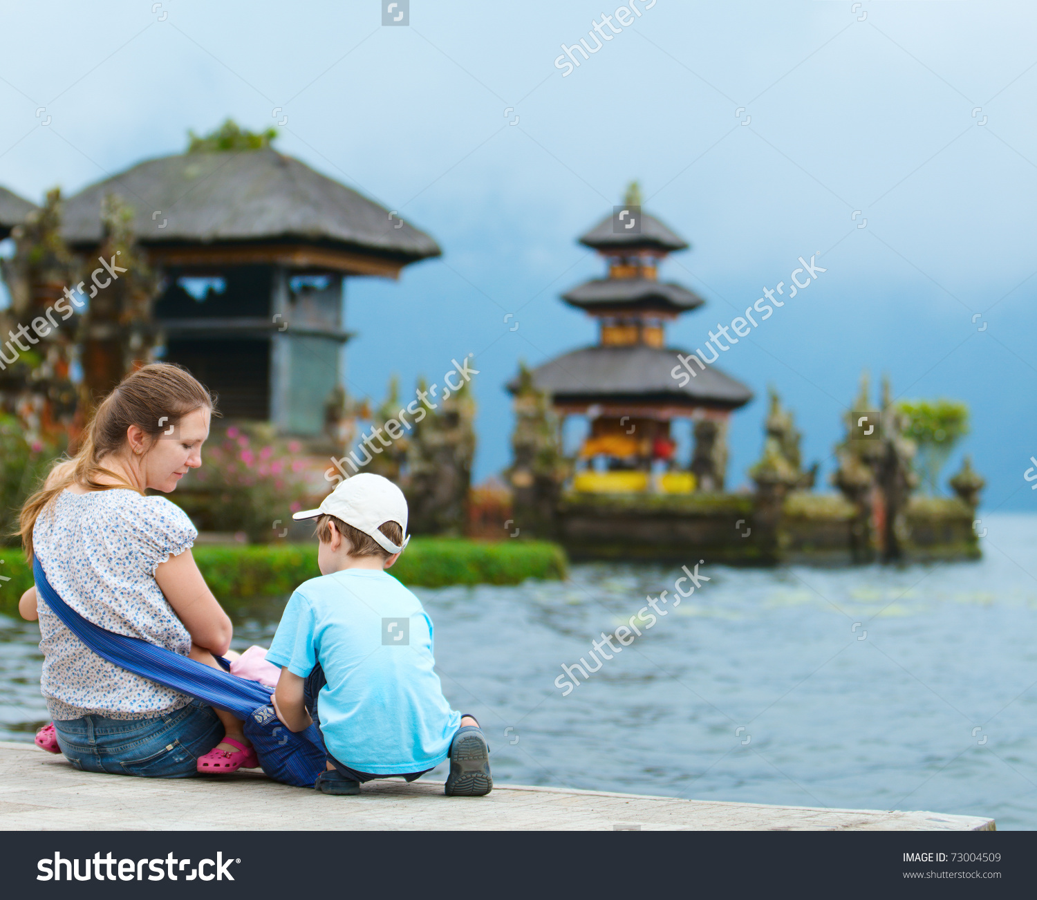 Family Enjoying Views Of Beautiful Bali Water Temple At Bratan.