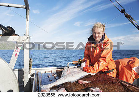 Stock Images of Young woman gutting halibut while commercial.