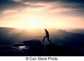 Stock Photography of Crazy hiker umping between rocks. Marvelous.