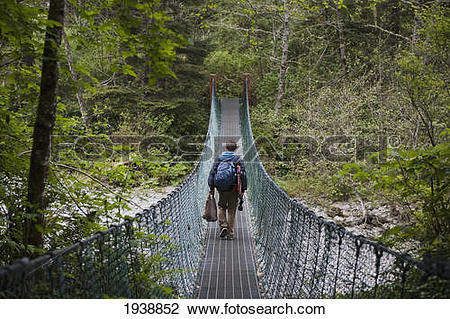 Stock Photo of A Person Walking Over A Suspension Bridge In China.