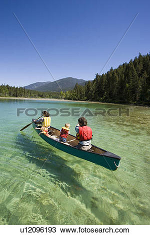 Stock Photo of Young family canoeing on Loon Lake in the East.