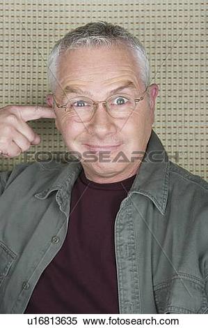 Stock Image of Older man putting finger in ear u16813635.