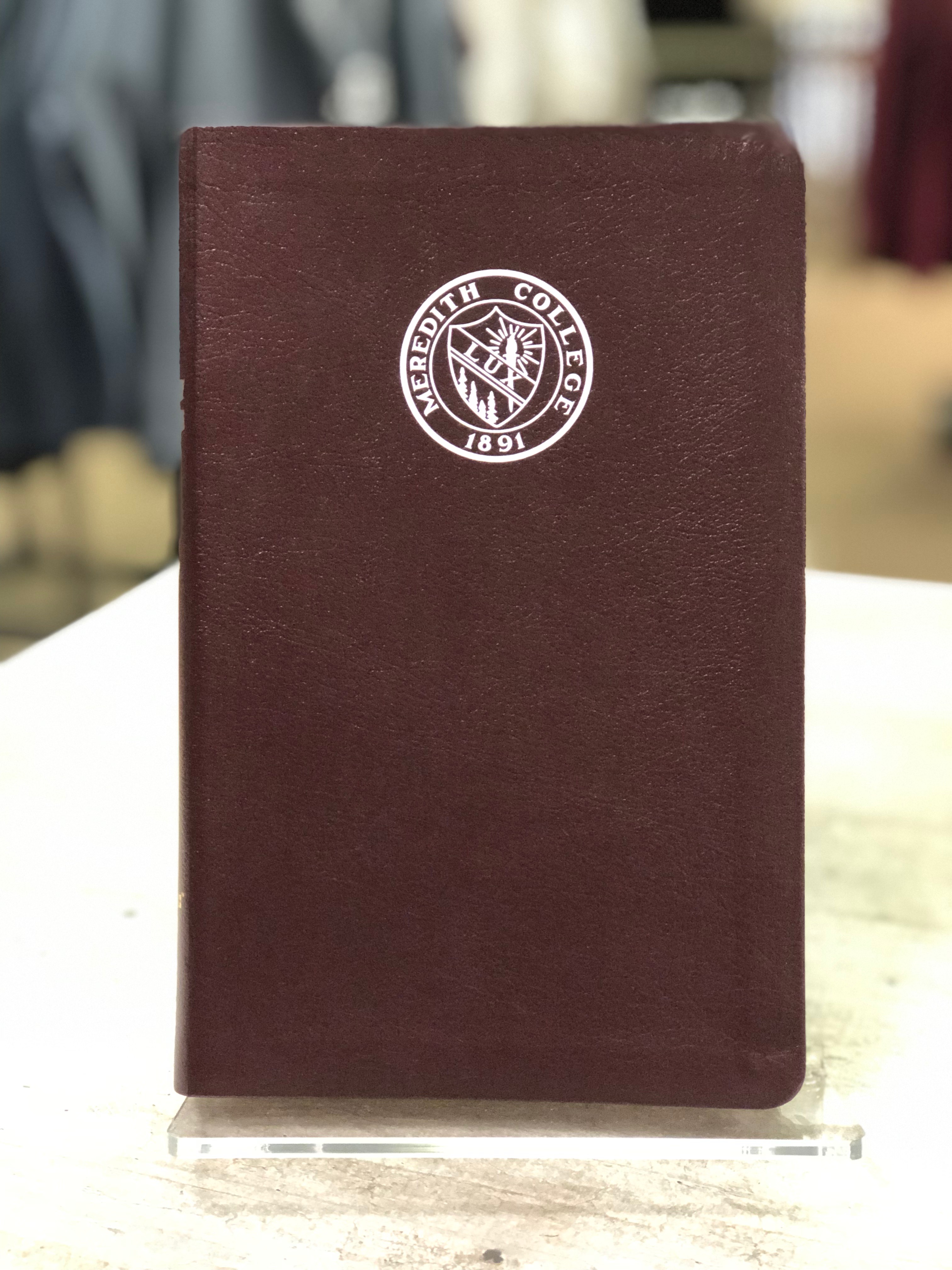 Bible with Meredith College Logo.