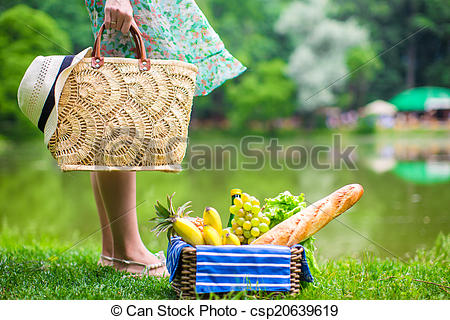 Stock Photography of Picnic basket with fruits, bread and hat on.