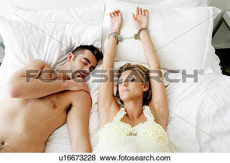 Pictures of Handcuffed woman in bed with man asleep beside.