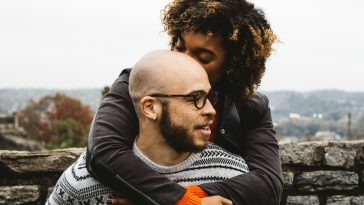 woman kissing man's head