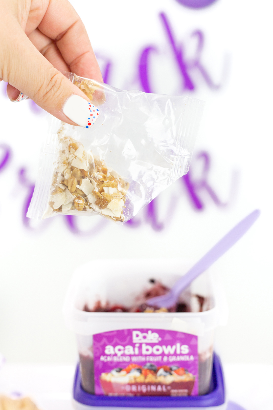 adding granola to acai bowl