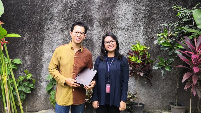 Two young entrepreneurs with a plaque